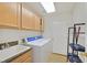 Functional laundry room with sink, cabinetry, and a washer and dryer, offering convenience at 6120 Farm Rd, Las Vegas, NV 89131
