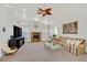 Bright living room with a stone fireplace and ceiling fan, perfect for relaxing at 6120 Farm Rd, Las Vegas, NV 89131