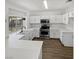 Bright, all-white kitchen with stainless steel appliances, quartz countertops and hardwood floors at 6701 Squaw Mountain Dr # 201, Las Vegas, NV 89130