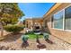 Scenic backyard with rock landscape, covered patio, and lush greenery at 7640 Fieldfare Dr, North Las Vegas, NV 89084