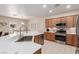 Well-lit kitchen featuring stainless steel appliances, wooden cabinets, and a convenient breakfast bar at 7640 Fieldfare Dr, North Las Vegas, NV 89084