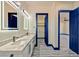 Modern bathroom boasts double sinks, and quartz counters, and blue accent doors with wood look tile flooring at 8625 Scarsdale Dr, Las Vegas, NV 89117
