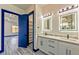 Modern bathroom boasts double sinks, and quartz counters, modern lighting and blue accent doors at 8625 Scarsdale Dr, Las Vegas, NV 89117