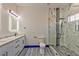 Bathroom featuring double sinks, a glass shower enclosure and modern fixtures and blue trim accents at 8625 Scarsdale Dr, Las Vegas, NV 89117