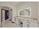 Hallway view of the lighted vanity featuring marble countertops and a large mirror at 8625 Scarsdale Dr, Las Vegas, NV 89117