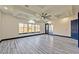 Spacious bedroom with tray ceilings, fan, grey laminate floors and views of the outdoor landscape at 8625 Scarsdale Dr, Las Vegas, NV 89117