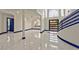 Open-concept foyer featuring marble floors, high ceilings, and sleek modern staircase at 8625 Scarsdale Dr, Las Vegas, NV 89117
