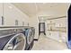 Laundry room with modern appliances and white cabinetry, offering a sleek and functional space at 8625 Scarsdale Dr, Las Vegas, NV 89117