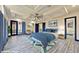Staged main bedroom with a tray ceiling, ceiling fan, wood-look tile flooring, and blue accents at 8625 Scarsdale Dr, Las Vegas, NV 89117
