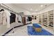 Walk-in closet is equipped with custom shelves, clothing racks and a center island with a blue cushion at 8625 Scarsdale Dr, Las Vegas, NV 89117