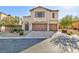 Exterior shot of a stucco two-story home with two-car garage, desert landscaping, and arched entry at 9085 Bridal Creek Ave, Las Vegas, NV 89178