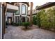 Private courtyard with stone pavers, lush greenery, and an arched doorway at 9325 Canyon Classic Dr, Las Vegas, NV 89144