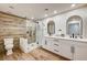 Bathroom showcases wood-look floors, double vanity, sleek glass shower, and toilet for a modern appeal at 9545 Eagle Valley Dr, Las Vegas, NV 89134