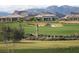 Scenic view of a lush green golf course with luxury homes and mountains in the background, a golfer's paradise at 10276 Romantico Dr, Las Vegas, NV 89135