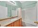 Well-lit bathroom with a granite vanity, a shower-tub combination, and tile walls at 10983 Pumpkin Ridge Ave, Las Vegas, NV 89135