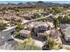 Breathtaking aerial view of home featuring a tile roof, desert landscaping, mountain views, and surrounding golf course at 11 Canoa Hills Dr, Henderson, NV 89052