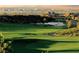 Scenic golf course view featuring rolling greens, a tranquil pond, and distant city skyline views at 11 Canoa Hills Dr, Henderson, NV 89052