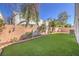 Spacious backyard featuring artificial turf, brick accents and privacy fencing at 1590 Raining Hills St, Henderson, NV 89052