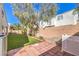 Charming backyard with low-maintenance artificial turf and inviting brick patio at 1590 Raining Hills St, Henderson, NV 89052