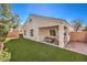 Spacious backyard with lush artificial turf and a covered patio, perfect for outdoor entertaining at 1590 Raining Hills St, Henderson, NV 89052