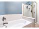The bathroom includes a separate soaking tub and shower with white tile and blue accent wall at 1590 Raining Hills St, Henderson, NV 89052
