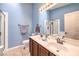 This bathroom features a double sink vanity, a large mirror, and a glass enclosed shower at 1590 Raining Hills St, Henderson, NV 89052