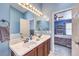 Bright bathroom features a double sink vanity, a large mirror and view of the bedroom at 1590 Raining Hills St, Henderson, NV 89052