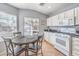A view of a modern kitchen with a breakfast nook, featuring a gas range and sleek countertops at 1590 Raining Hills St, Henderson, NV 89052