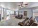 A bright and airy living room featuring comfortable seating, a ceiling fan, and access to the kitchen at 1590 Raining Hills St, Henderson, NV 89052