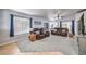 A spacious living room with plush seating, a ceiling fan, and ample natural light from the large windows at 1590 Raining Hills St, Henderson, NV 89052