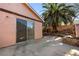 View of the back of the home with tropical plants, a waterfall feature, and a concrete patio at 1789 Winterwood Blvd, Las Vegas, NV 89142