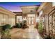 Welcoming entrance to home with double glass doors, stone accents, manicured greenery, and wrought iron decor at 2062 Dipinto Ave, Henderson, NV 89052