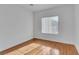 Minimalist bedroom featuring hardwood floors, white walls, and natural light from a large window at 2219 Sawtooth Mountain Dr, Henderson, NV 89044