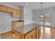 Kitchen with a central island, wood cabinets, and views to the outdoor patio through glass doors, creating an open feel at 2219 Sawtooth Mountain Dr, Henderson, NV 89044