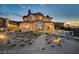 Landscaped backyard with a paved pathway leading to an infinity pool, showcasing mountain and sunset views at 30 Via Tiberius Way, Henderson, NV 89011