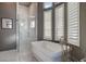 Bright bathroom featuring soaking tub with faucet and glass-enclosed shower at 30 Via Tiberius Way, Henderson, NV 89011