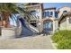 Front exterior featuring a curved staircase leading to a grand entrance and a stone driveway with lush landscaping at 30 Via Tiberius Way, Henderson, NV 89011