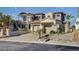 Beautiful two-story home showcasing a stone exterior, arched windows, and a three-car garage, nestled in a landscaped yard at 30 Via Tiberius Way, Henderson, NV 89011