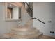 Beautiful staircase with wood steps, wrought iron railing, and a large decorative mirror at 30 Via Tiberius Way, Henderson, NV 89011