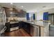 Modern kitchen features granite countertops, stainless steel appliances, dark cabinets, and wood flooring at 357 Stone Fly Rd, North Las Vegas, NV 89032