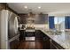 Modern kitchen features granite countertops, stainless steel appliances, dark cabinets, and wood flooring at 357 Stone Fly Rd, North Las Vegas, NV 89032