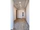 Bright hallway with wood look tile floors, recessed lighting, and white trim at 370 Haddocks Hall Pl, Henderson, NV 89011