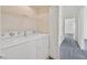Well-lit laundry room with white washer and dryer and wire shelving for storage at 3933 Lazy Pine St # 204, Las Vegas, NV 89108