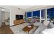 Modern living room with a gray sectional sofa, wood flooring, and a stunning city view at night at 4471 Dean Martin Dr # 2705, Las Vegas, NV 89103