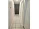 Hallway featuring tiled floors, neutral-toned walls, and doors for easy navigation through the house at 4480 Annie Oakley Dr, Las Vegas, NV 89121