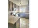 Functional kitchen with tile floor, white appliances, plenty of cabinets, and quartz countertops at 4480 Annie Oakley Dr, Las Vegas, NV 89121