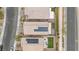 Birds-eye view of three homes with solar panels, green grass, and patio furniture at 4519 Stardusk Falls Ave, North Las Vegas, NV 89084