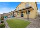 View of the manicured backyard with a covered patio, artificial turf, and cozy seating at 4519 Stardusk Falls Ave, North Las Vegas, NV 89084