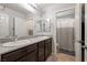 Well-lit bathroom featuring dual sinks, granite counters, and a shower with a striped curtain at 4519 Stardusk Falls Ave, North Las Vegas, NV 89084