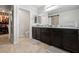 Bathroom features double sinks, dark wood cabinets, granite countertops, and a separate room with toilet and closet at 4519 Stardusk Falls Ave, North Las Vegas, NV 89084
